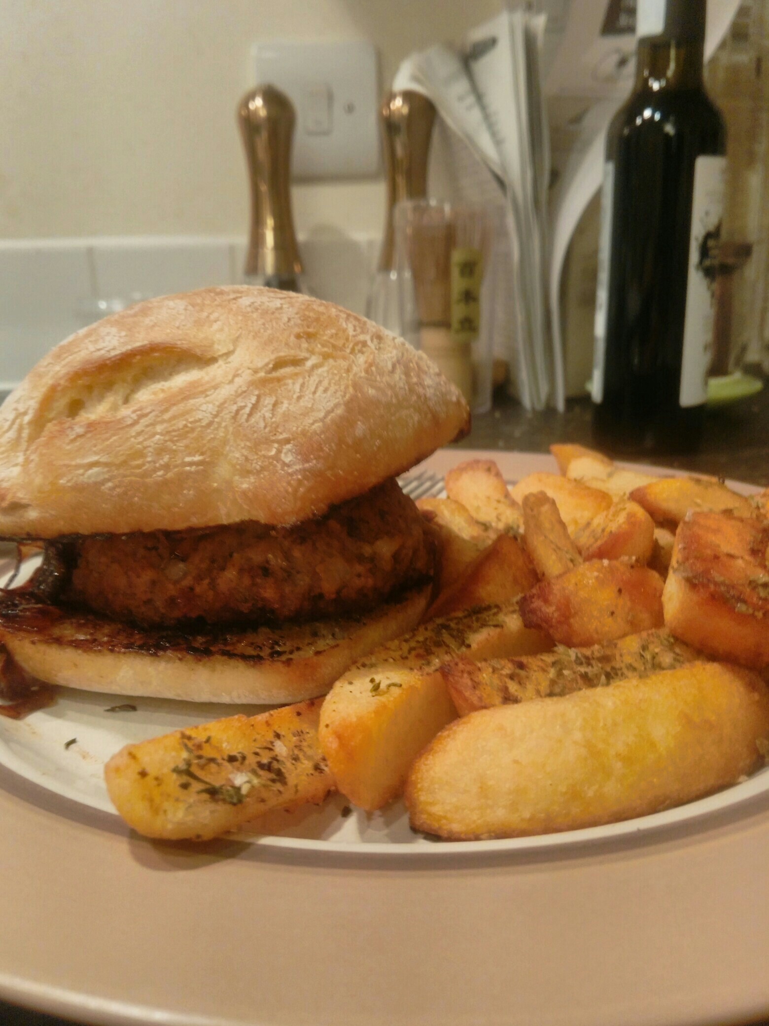 Burger in a bun and chips on a plate