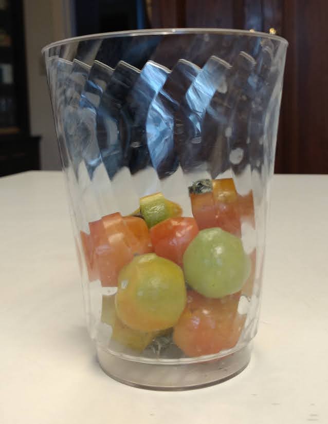 photo: cherry tomatoes in various stages of ripening, in a clear plastic cup